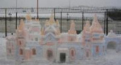 Снежные скульптуры на фоне бетонных заборов